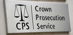 A white sign with a black illustration of the scale of justice next to black writing that reads Crown Prosecution Service.