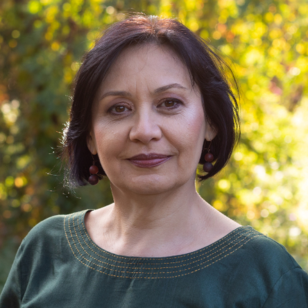 A middle-aged woman with bobbed hair smiles and looks straight into the camera.