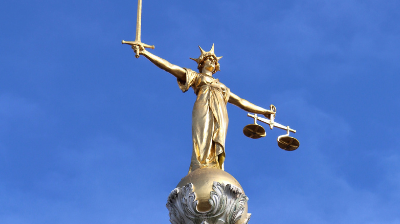 A gold statue of Lady Liberty sits atop the Old Bailey building in London. The Old Bailey is the Central Criminal Court of England and Wales.